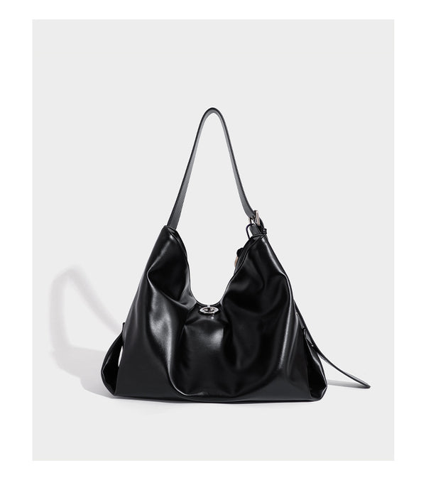 Große schwarze, weich fallende Hobo-Schultertasche in glänzender Lederoptik mit mit Ösen besetztem Riemen, silberfarbenen Metallbeschlägen und abnehmbarem