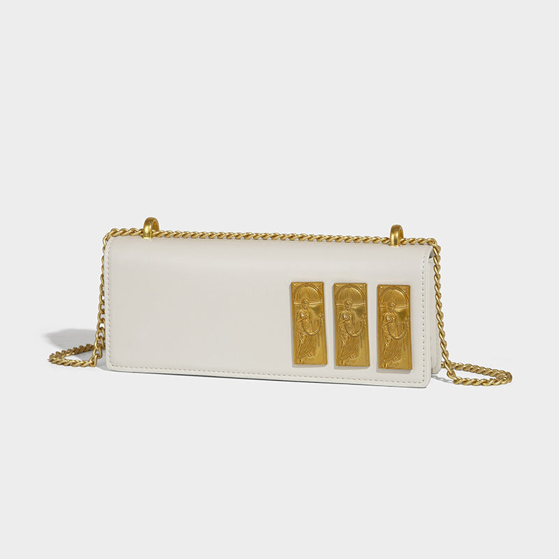 Structured rectangular crossbody bag with glossy finish, three vertical gold-tone embossed plaques, and gold chain strap