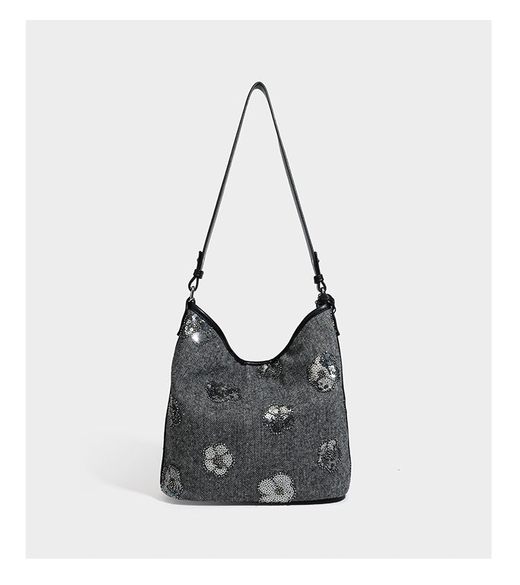 Lässig fallende Hobo-Schultertasche aus anthrazitfarbenem Webstoff mit floraler Stickerei aus silberfarbenen Pailletten, schwarzem Besatz in Lederoptik und langem