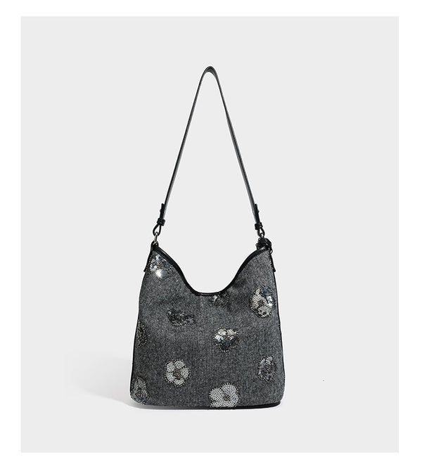 Lässig fallende Hobo-Schultertasche aus anthrazitfarbenem Webstoff mit floraler Stickerei aus silberfarbenen Pailletten, schwarzem Besatz in Lederoptik und langem
