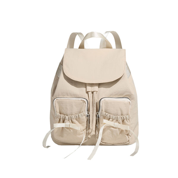 Soft matte nylon drawstring backpack with ruched bow-detail front zip pockets, top carry handle, and silver-tone hardware