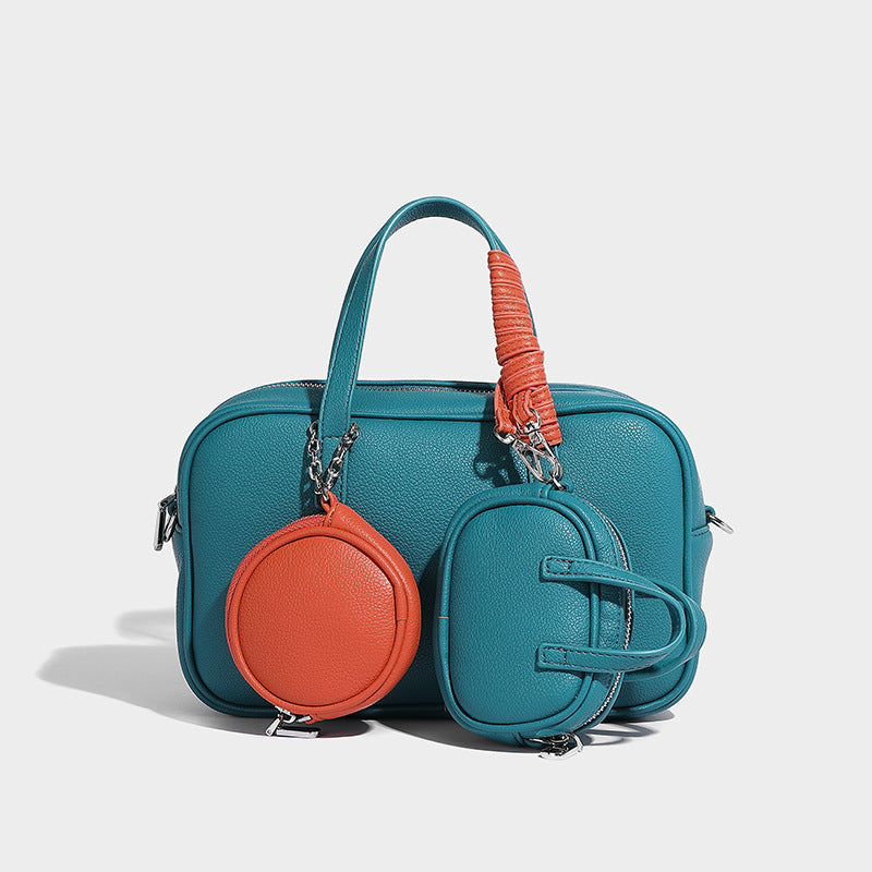 Structured pebbled leather-look Boston bowling bag in tan with blue detachable round mini pouch, dual top handles, and