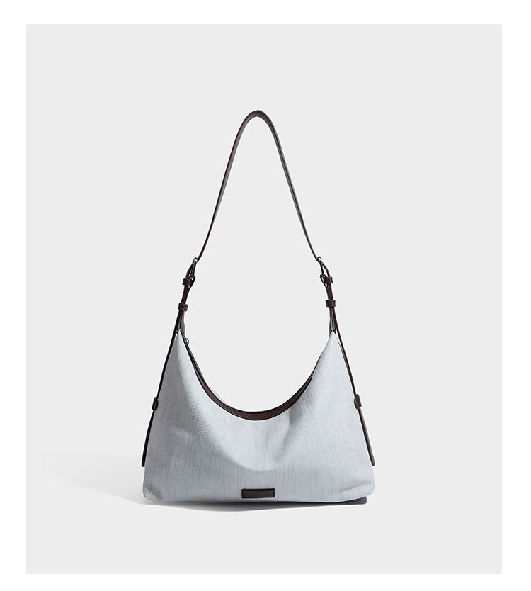 Slouchy olive green canvas hobo shoulder bag with black leather-look trim, zip-top closure, and adjustable strap, detail view