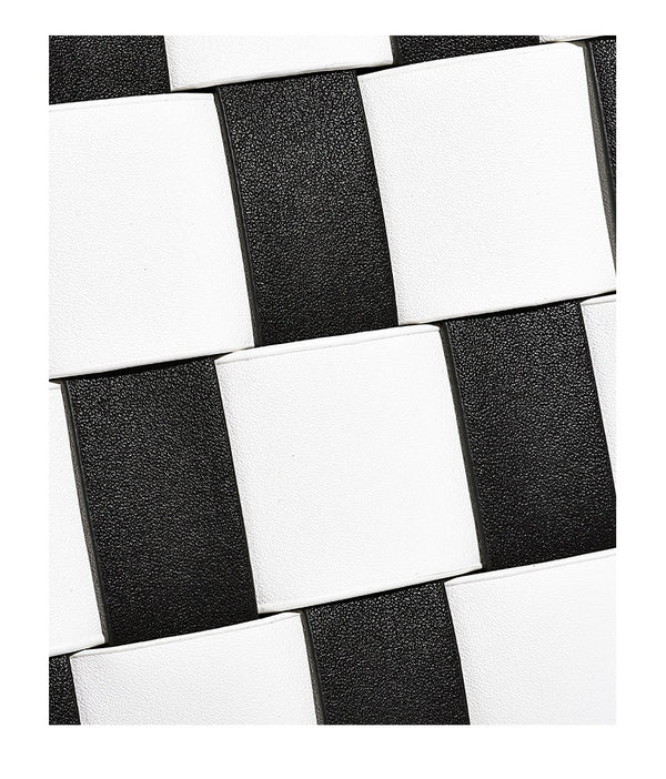 Hand-woven black-and-white checkerboard bucket bag with smooth black trim, silver-tone ring hardware, and adjustable