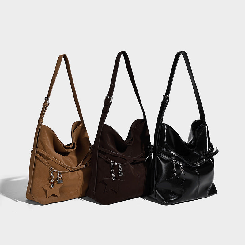 Large slouchy matte leather-look shoulder hobo bag with front zip pocket and dangling star and lock charms in silver-tone