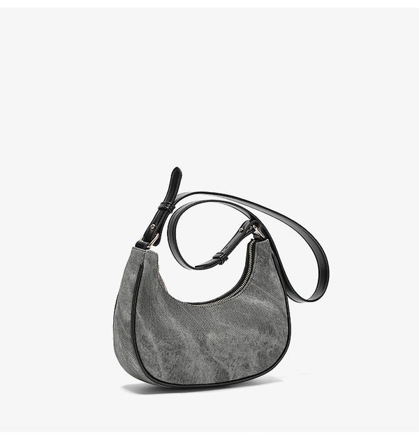 Small gray crescent half-moon shoulder bag with black leather-look trim, gold-tone zipper, and adjustable slim strap, detail