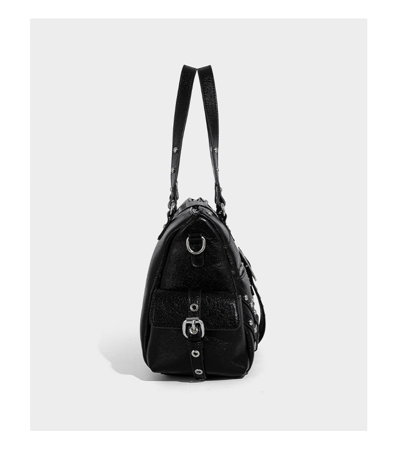 Schwarze, glänzende Henkeltasche mit genarbter Struktur, silberfarbenen Nieten, Riemendetail mit Schnalle, zwei Henkeln und breitem, mit Nieten besetztem Schulterriemen