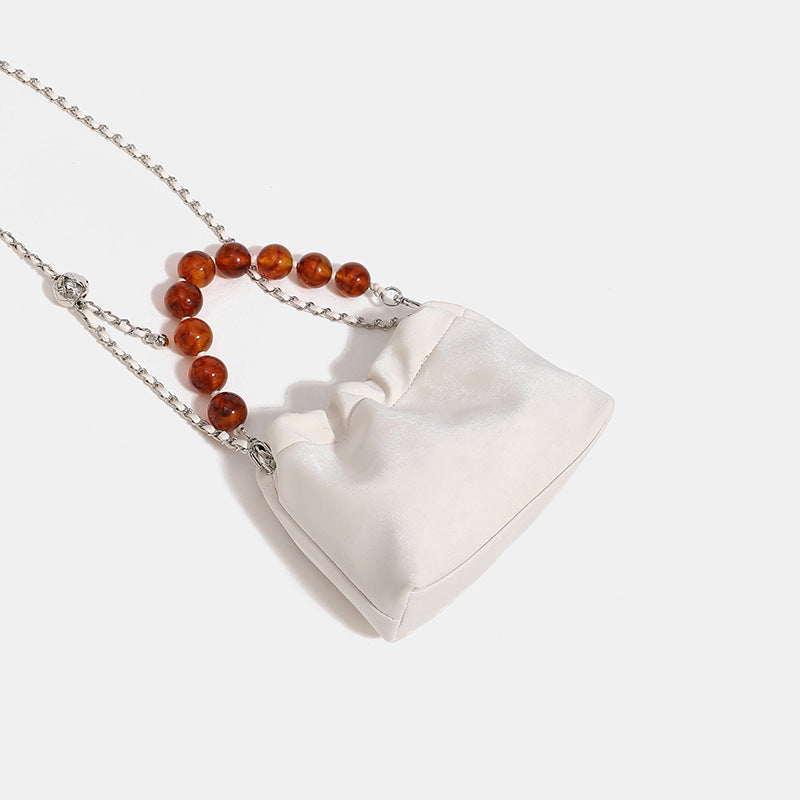 Ruched drawstring bucket bag with amber resin bead handle and silver-tone chain strap, detail view 4