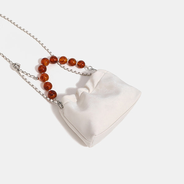 Ruched drawstring bucket bag with amber resin bead handle and silver-tone chain strap, detail view 4