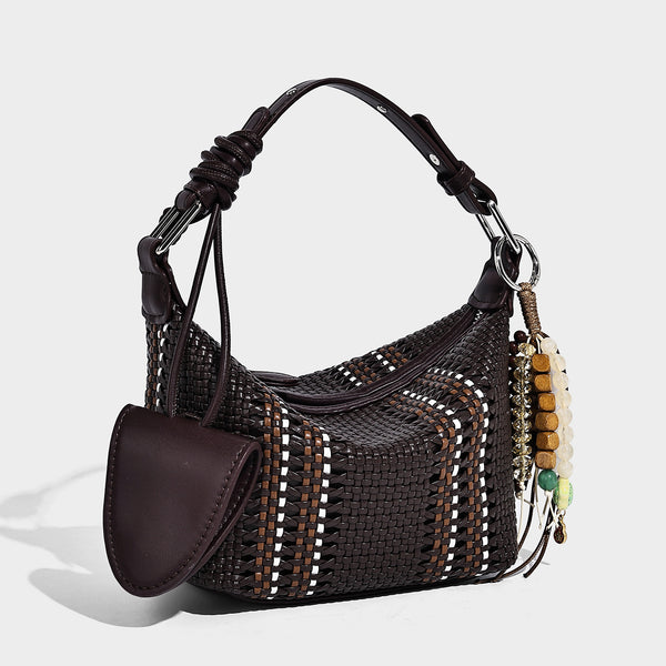 Small woven crescent shoulder bag with leather-look trim, zip closure, silver-tone ring hardware, and beaded tassel charm