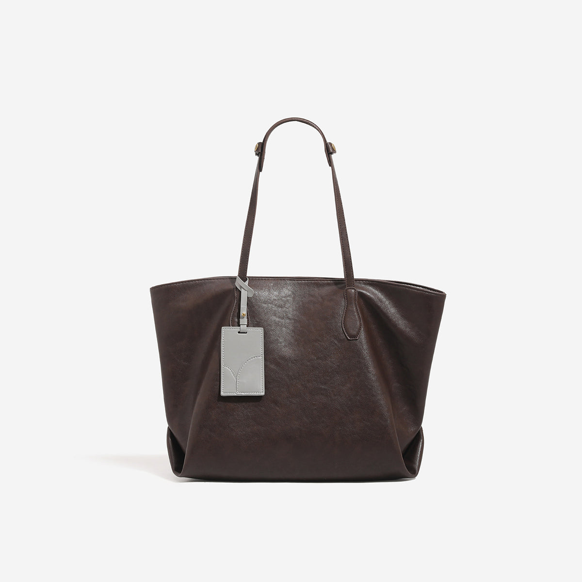 Oversized slouchy leather-look tote bag with long shoulder straps, contrast grey hanging tag, and silver-tone hardware