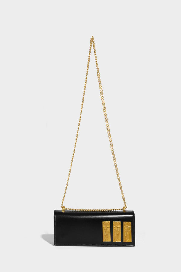 Structured rectangular crossbody bag with glossy finish, three vertical gold-tone embossed plaques, and gold chain strap