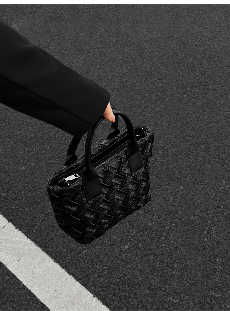 Small black glossy woven tote bag with dual top handles and detachable shoulder strap, detail view 10