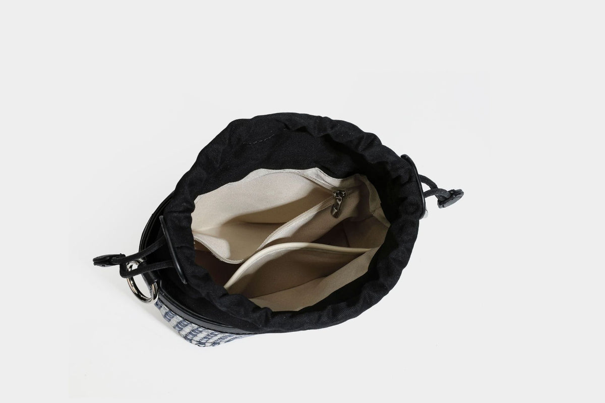 Small structured woven checker bucket bag with braided top handle, drawstring closure, and silver-tone hardware in black