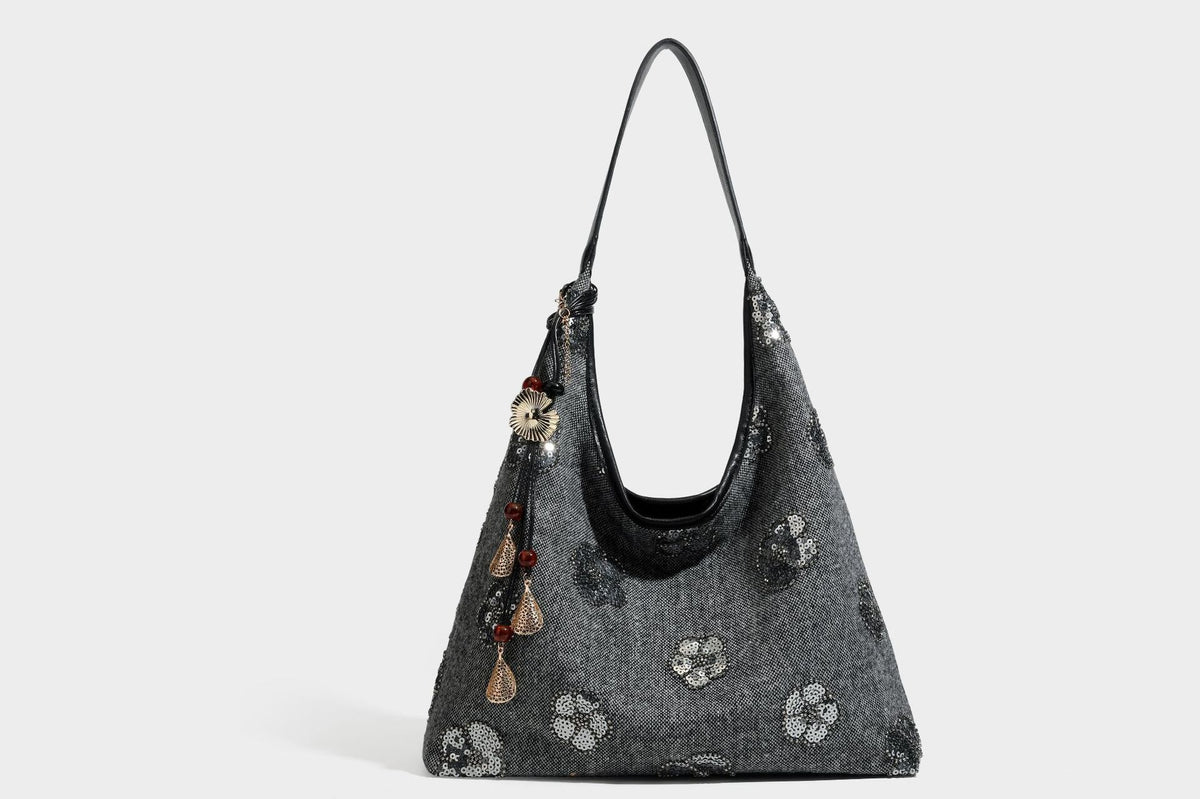 Lässig fallende, trapezförmige Schulter-Tote in Anthrazitgrau mit floralen Paillettenmotiven in Silber, Riemen in Lederoptik und herabhängendem Perlenbesatz
