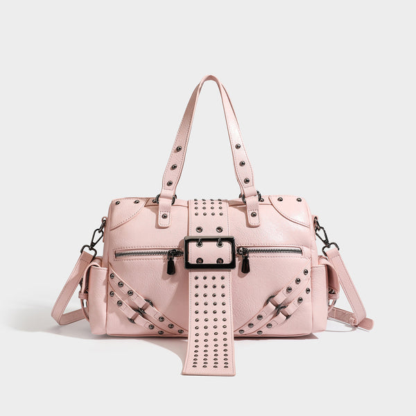 Structured pink leather-look satchel bag with gunmetal studded trim, rectangular buckle strap, dual top handles, and, detail