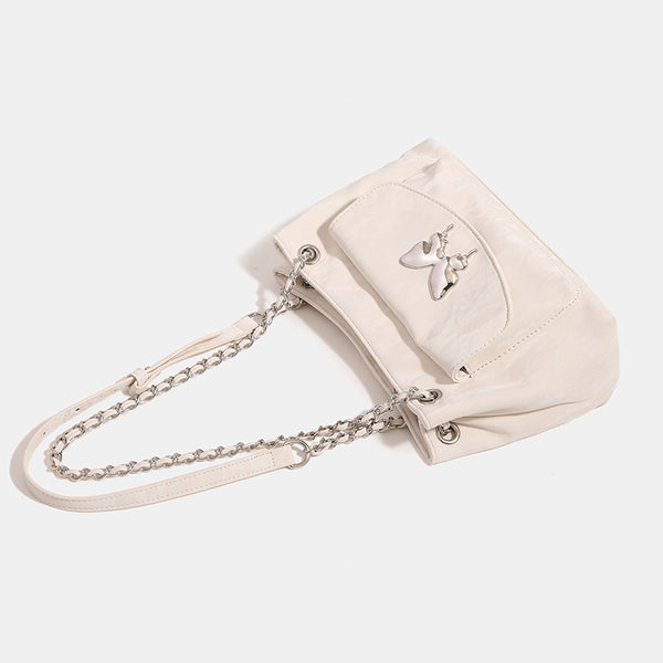 Soft rectangular glossy leather-look shoulder bag with silver chain strap, butterfly ornament on front flap pocket, and