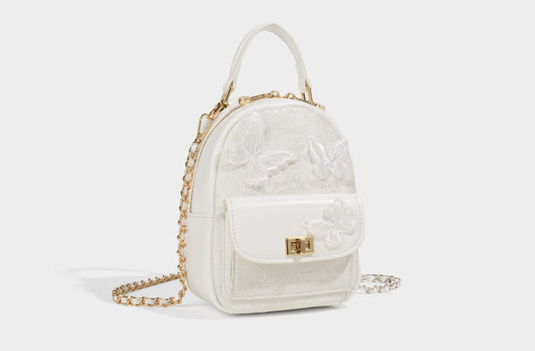 Structured mini backpack handbag with butterfly embroidery, gold-tone chain strap, and turn-lock front flap pocket, detail