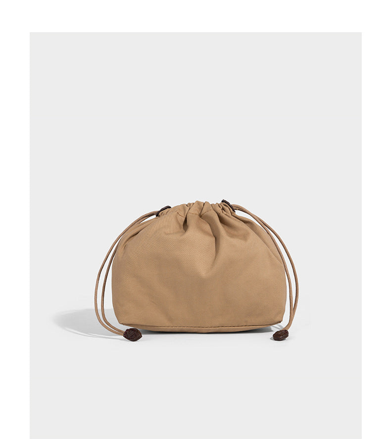 Structured chevron woven leather-look tote bag with braided top handles, gold feather charm, and adjustable shoulder strap