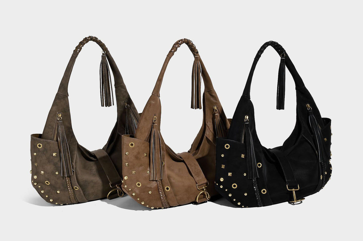 Slouchy crescent hobo bag in matte brown suede-like finish with gold-tone studs, grommets, braided top handle, tassel side