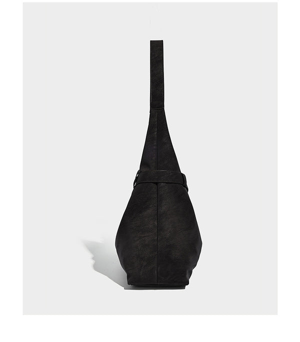 Slouchy oversized shoulder tote bag with matte textured finish, wrap-around buckle strap, and detachable front zip pouch