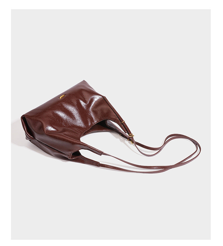 Lässige Hobo-Schultertasche mit offenem Oberteil in glänzender, geknautschter dunkelbrauner Lederoptik mit schmalem verstellbarem Riemen und goldfarbenem
