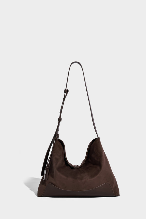 Dark brown slouchy hobo bag with matte suede-look body, smooth leather-look base trim, adjustable shoulder strap, and, detail
