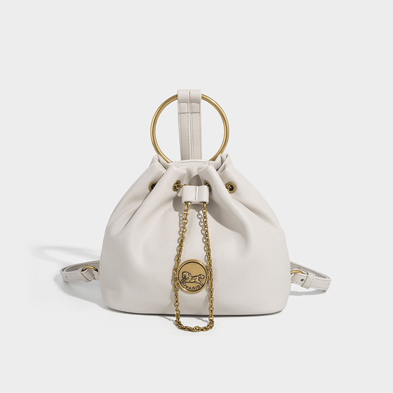 Kleine Bucket-Tasche aus genarbter Lederoptik mit goldfarbenem Ringhenkel, Kettenmedaillon als Akzent und verstellbarem Rucksack