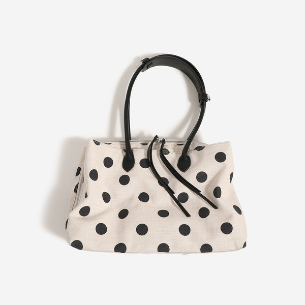 Cream canvas tote bag with black polka dots, rounded leather-look handles, and zip-top closure, detail view 3