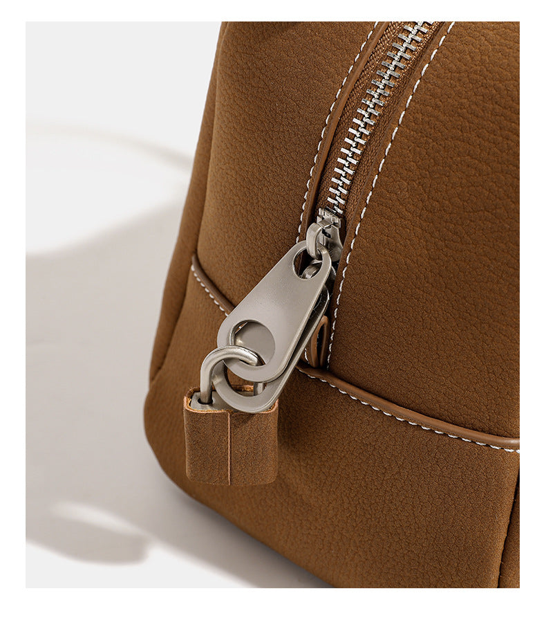 Kompakte, strukturierte Henkeltasche mit matter genarbter Oberfläche, geknoteten Doppelhenkeln, goldenem Schlüsselanhänger und abnehmbarem, Detail