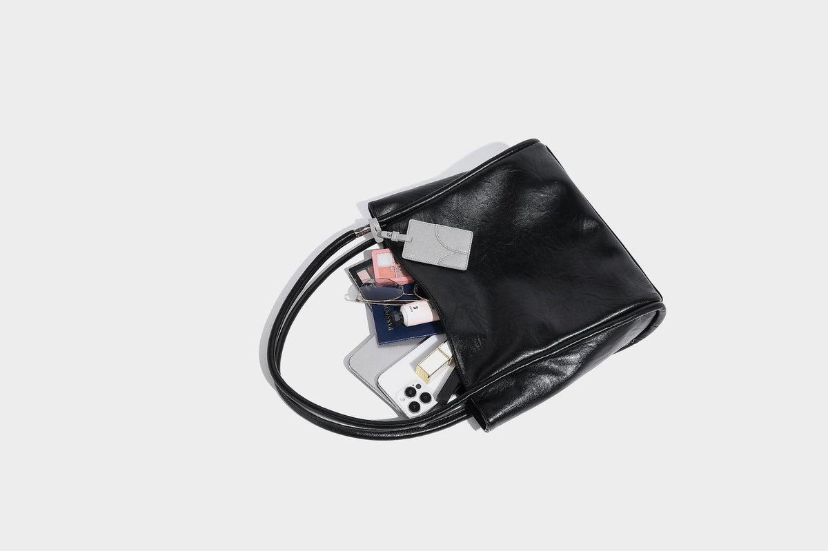 Glänzende Tote-Bag in schwarzer Lederoptik mit zwei runden Tragegriffen und silberfarbenen Beschlägen, Detailansicht 25