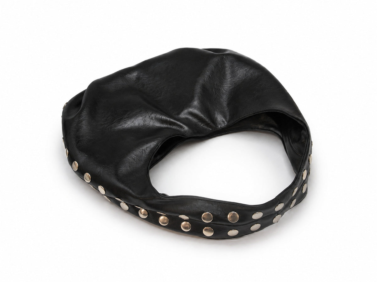 Schwarze Hobo-Bag in Lederoptik mit Halbmondsilhouette, silberfarbenen kuppelförmigen Nieten entlang der Seitennaht und einem breiten einzelnen Schlaufenhenkel, Detailaufnahme