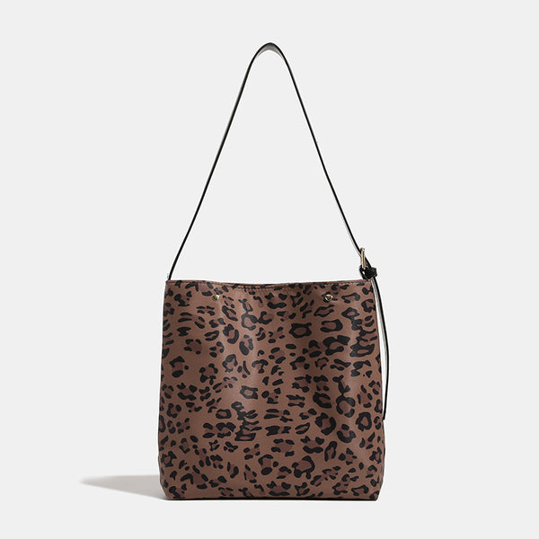 Brown and black leopard print canvas bucket bag with adjustable black leather-look shoulder strap and gold-tone hardware