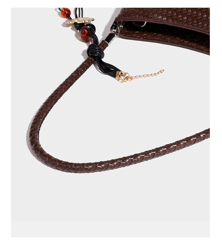 Woven-texture hobo shoulder bag in brown with braided top handle, adjustable crossbody strap, front flap pocket, and, detail