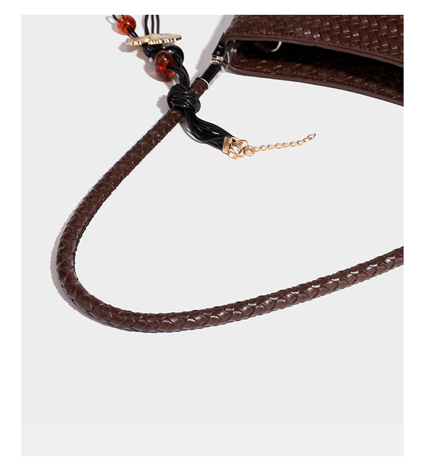 Woven-texture hobo shoulder bag in brown with braided top handle, adjustable crossbody strap, front flap pocket, and, detail
