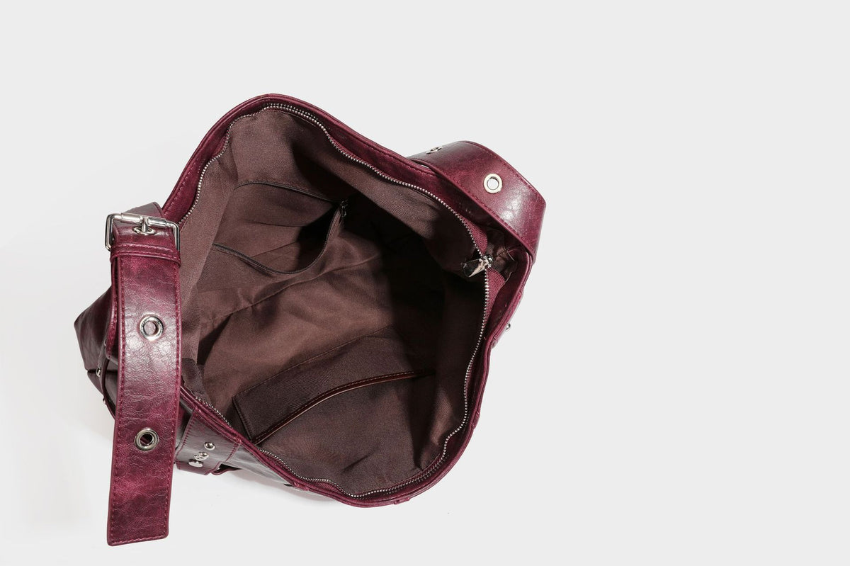 Lässige Hobo-Schultertasche in glänzender Lederoptik mit silberfarbenen Nieten, Riemendetail mit Schnalle und Reißverschluss oben