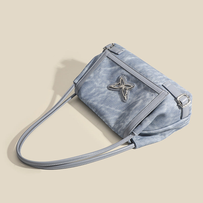 Washed leather-look shoulder tote bag with silver butterfly emblem and buckle hardware, detail view 4