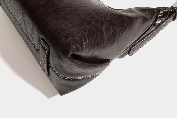 Slouchy hobo shoulder bag in glossy crinkled leather-look finish with zip-top closure and silver-tone ring hardware, detail