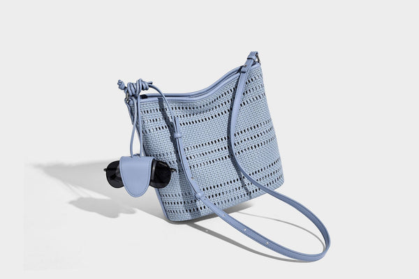 Handwoven open-weave shoulder bag with leather-look trim, knotted adjustable strap, and clip-on sunglasses sleeve pouch