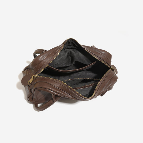 Structured matte leather-look bowling bag with snap-flap and zip front pockets, looped top handles, and antique gold-tone