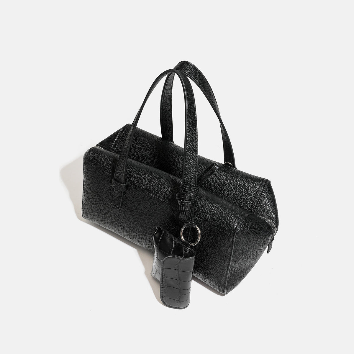 Structured pebbled leather-look top-zip barrel bag with dual handles, detachable shoulder strap, and attached croc-pattern