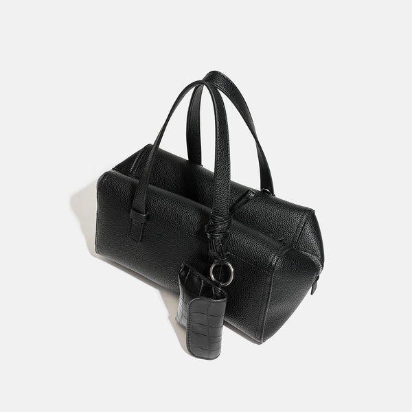 Structured pebbled leather-look top-zip barrel bag with dual handles, detachable shoulder strap, and attached croc-pattern