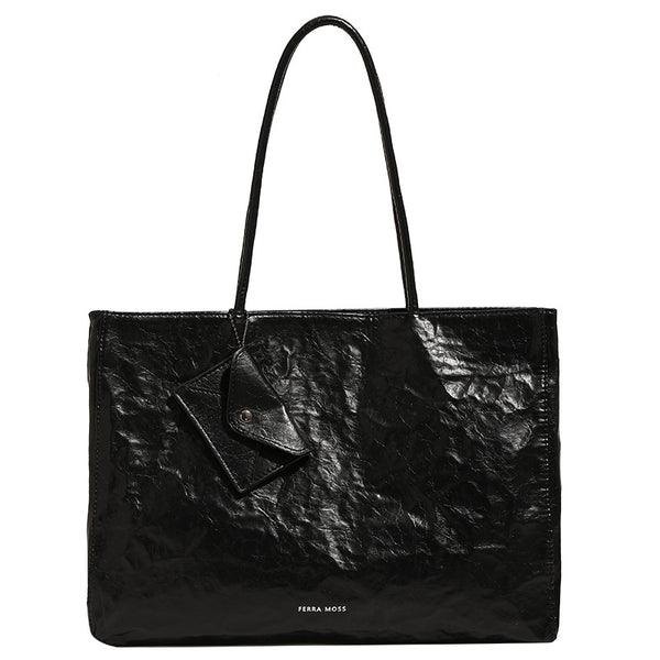 Large glossy crinkled rectangular tote bag with long double handles and hanging envelope snap tag, detail view 5