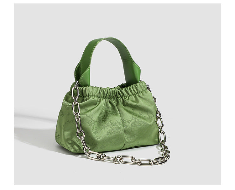 Small ruched satin-finish cloud bag with elasticized drawstring top, short top handle, and chunky silver-tone chain strap