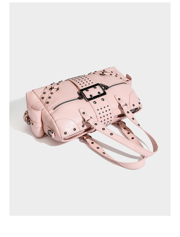 Structured pink leather-look satchel bag with gunmetal studded trim, rectangular buckle strap, dual top handles, and, detail
