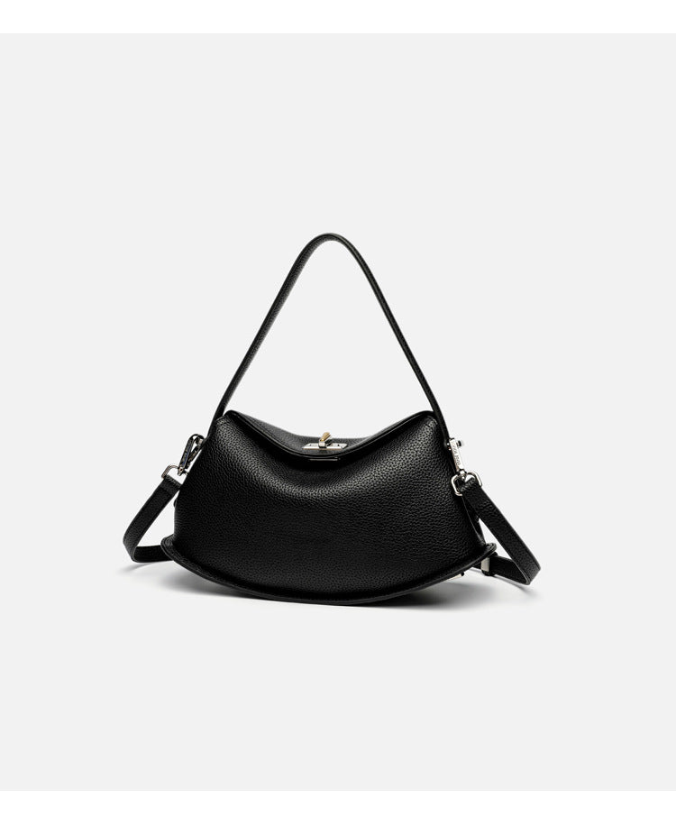 Pebbled leather-look half-moon saddle bag with turn-lock flap closure, top handle, and detachable crossbody strap, detail