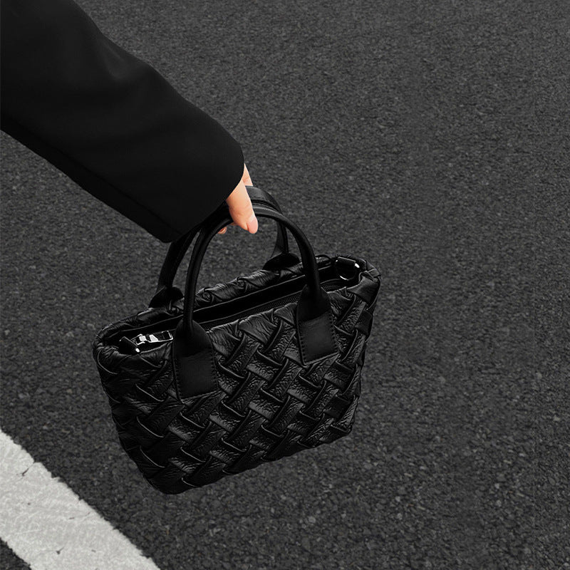 Small black glossy woven tote bag with dual top handles and detachable shoulder strap, detail view 2