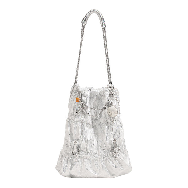 Slouchy lace-texture bucket bag with silver-tone chain strap, draped chain hardware, and shell charms, detail view 5