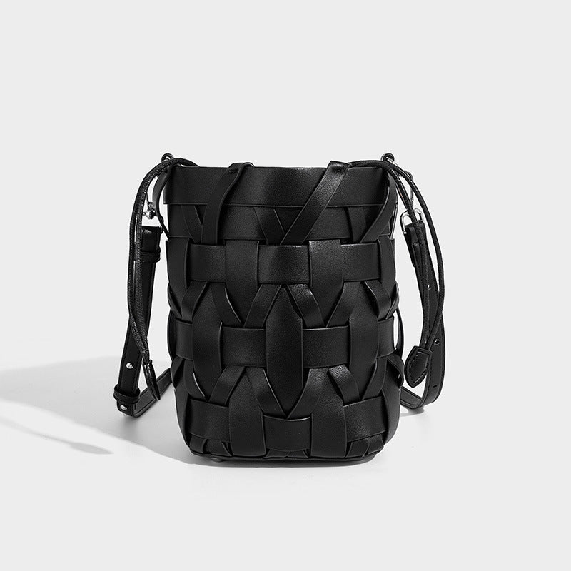 Small woven leather-look bucket bag with interlaced strip exterior, drawstring closure, and adjustable crossbody strap