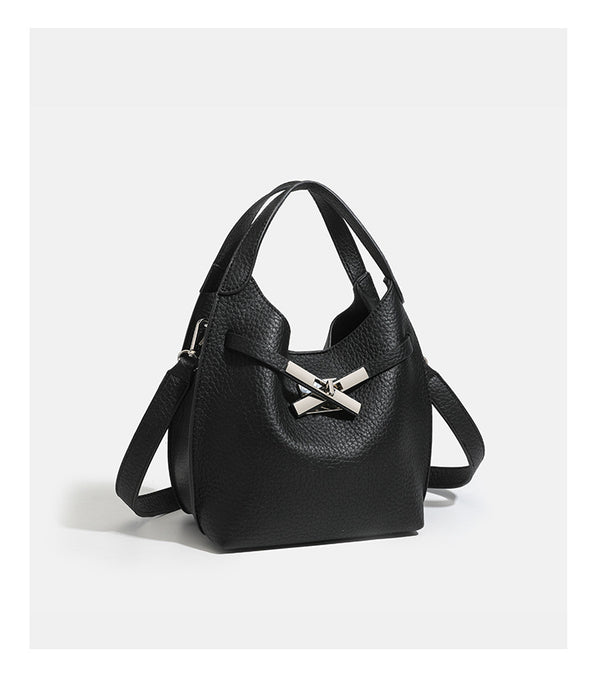 Compact pebbled leather-look shoulder bag with crossed silver-toned metal front closure, short top handle, and long, detail